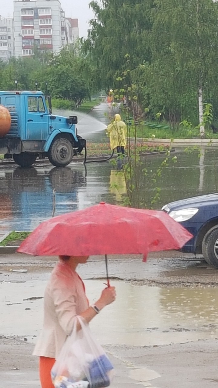 В Ухте в ливень рабочие поливали цветочную клумбу