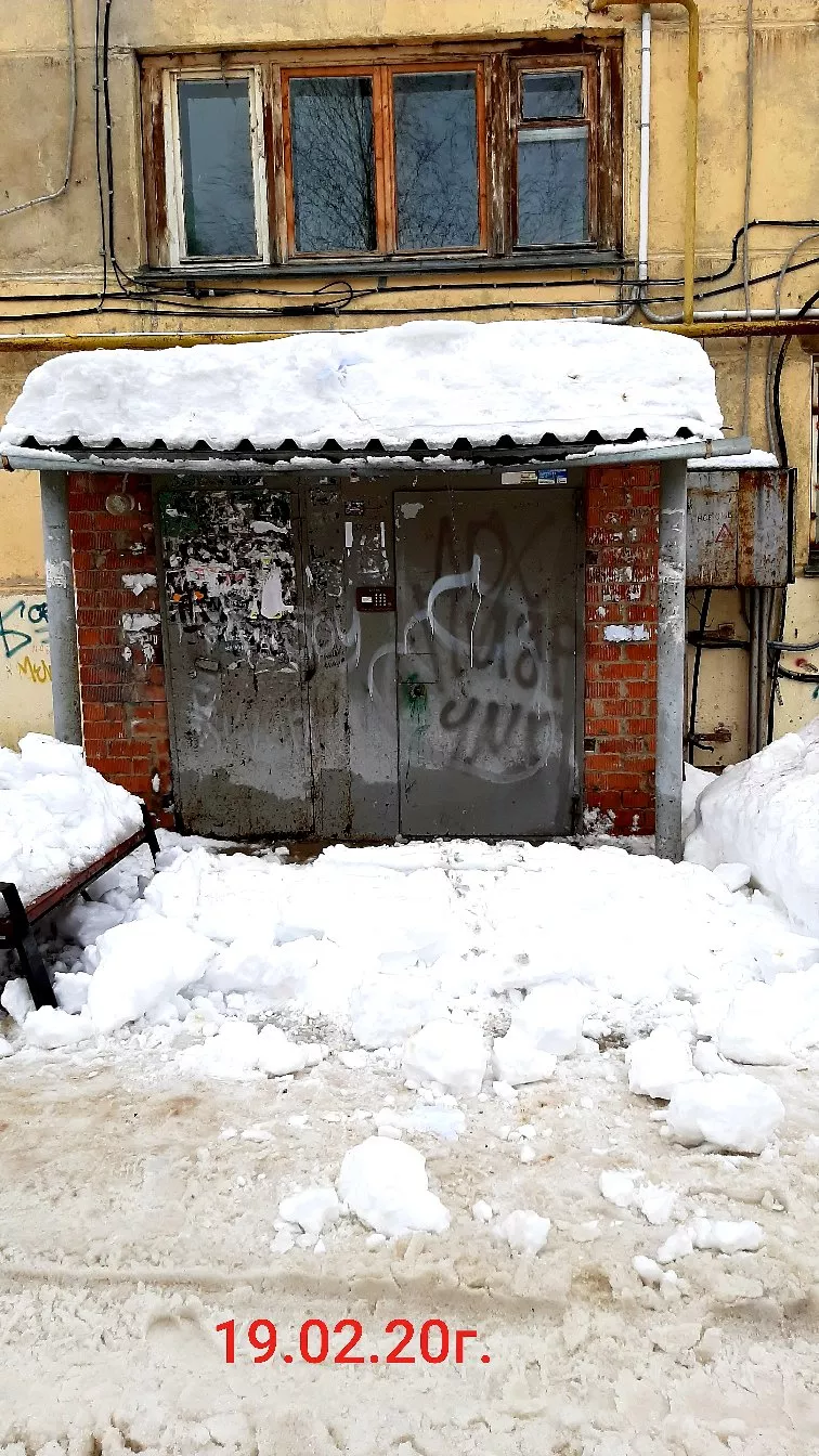 Фото к статье: Ухтинка лопатой раскопала вход в свой подъезд после обвала снега с крыши